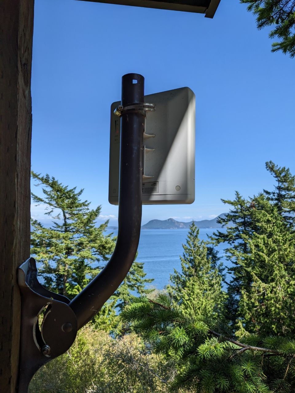 A photo of a wireless point to point radio, with Washington mountains and forest in the background