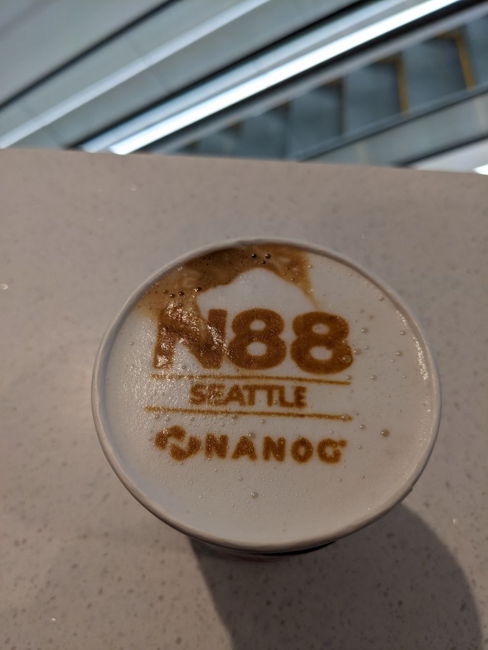 A cup of coffee with latte art saying "N88 - Seattle - NANOG"
